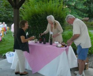 Laurie Mauser serving complimentary wine to the guests.