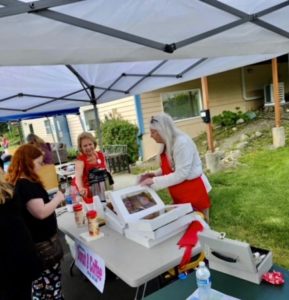 2024 Laurie serving donuts and coffee.